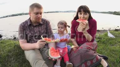 <strong>大家一起</strong>吃西瓜快乐的一家人在夏日的池塘边野餐